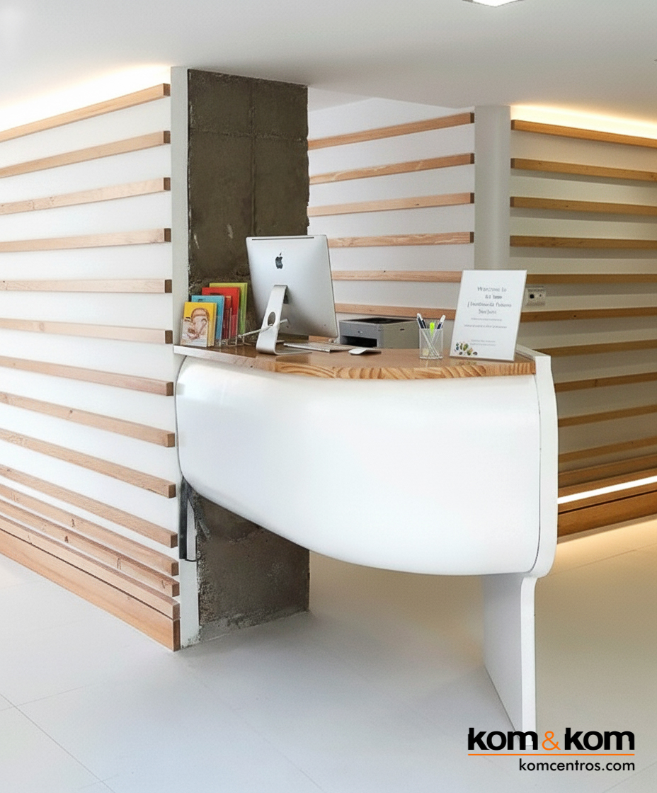 Mostrador curvo y abombado de recepción en clínica dental de Alicante, con iluminación sutil y paredes alistonadas de madera de inspiración nórdica.